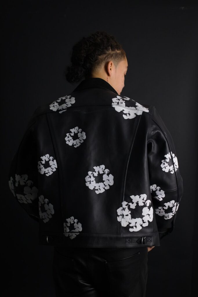 A man in a black jacket with white flowers on it